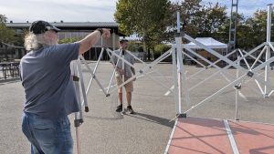 Guy participe à l'installation d'un barnum pour la scène